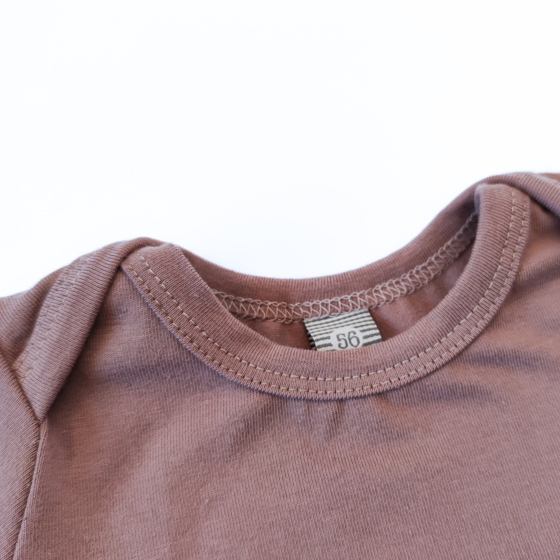 Ausschnittdetail eines Babybodys mit amerikanischem Ausschnitt in der Farbe rosa