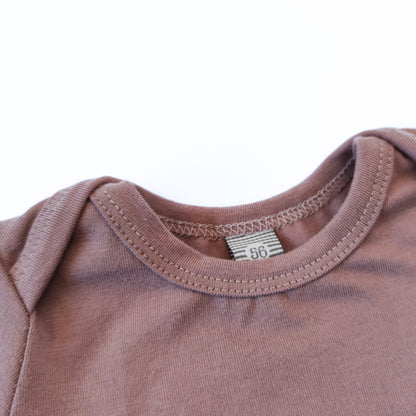 Ausschnittdetail eines Babybodys mit amerikanischem Ausschnitt in der Farbe rosa